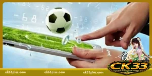 Hand interacting with a smartphone displaying a football field interface and digital betting data